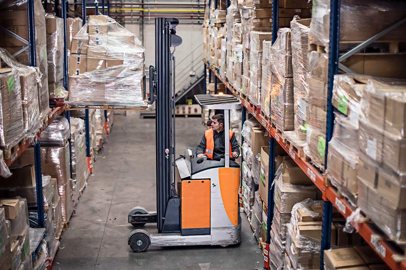 forklift operator inside a large warehouse