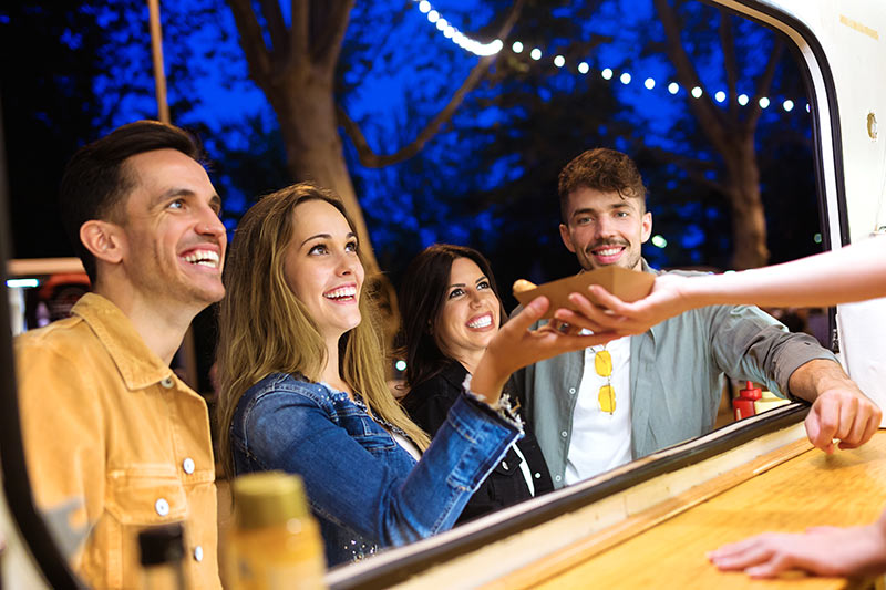 happy customers getting food from a food truck