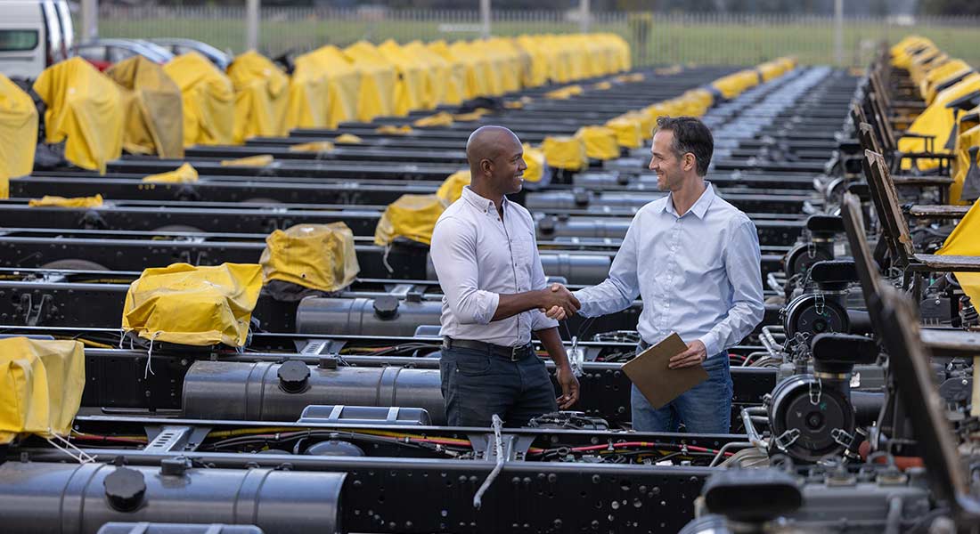 equipment sales manager shaking hands with customer on an equipment lot, six cash flow management tips for vendors