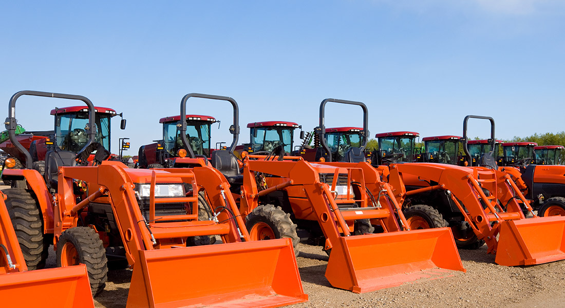 row of red front loaders under sunny skies at an equipment dealer lot, how dealers can prepare for extreme weather